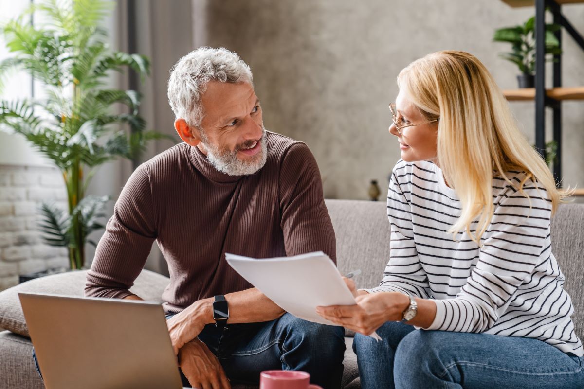 Couple reviewing documents sitting on a sofa